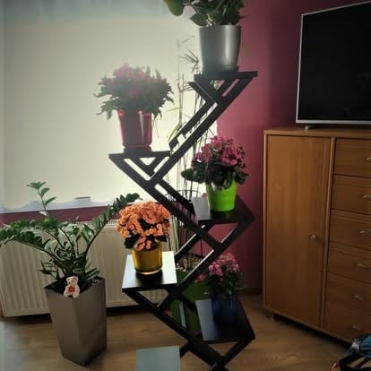 Nowoczesny kanciasty czarny kwietnik z doniczkami z różowymi i pomarańczowymi kwiatami